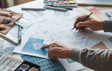Designer designing drawing sketch pattern geometric flower seamless wallpaper fabric textile fashion industry. artistic design studio