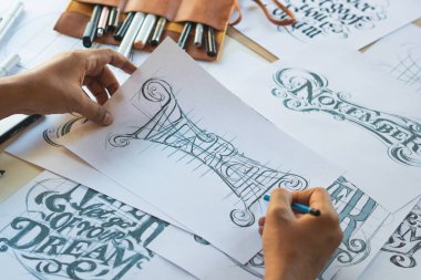 Tipografi Hattatçısı çizim çizimi yazarken imlâ edilen kalem fırçası mürekkep tablosu çizimlerine izin veriyor. İş yeri tasarım stüdyosu.