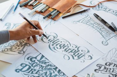 Tipografi Hattatçısı çizim çizimi yazarken imlâ edilen kalem fırçası mürekkep tablosu çizimlerine izin veriyor. İş yeri tasarım stüdyosu.