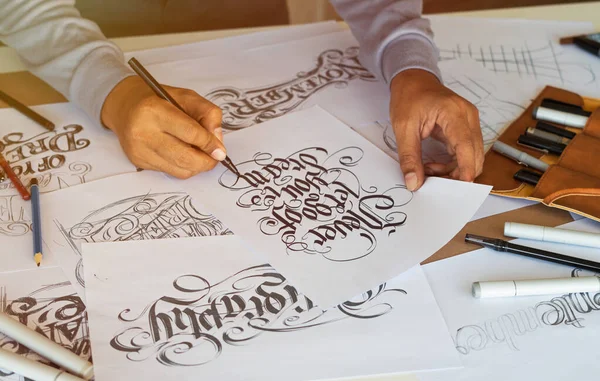 Tipografi Hattatçısı çizim çizimi yazarken imlâ edilen kalem fırçası mürekkep tablosu çizimlerine izin veriyor. İş yeri tasarım stüdyosu.