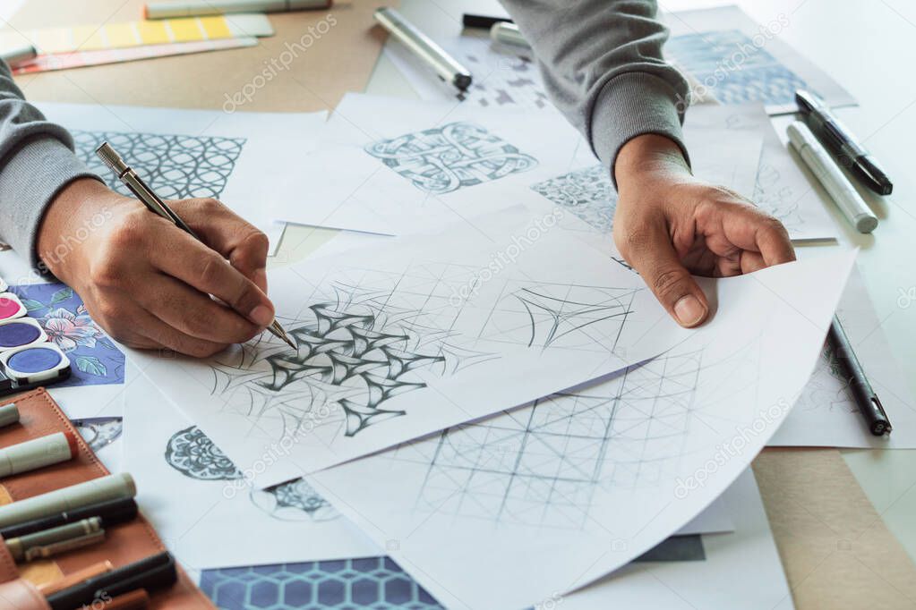 Designer designing drawing sketch pattern geometric flower seamless wallpaper fabric textile fashion industry. artistic design studio