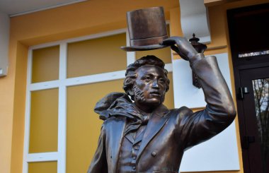POLTAVA, UKRAINE - MAY 1, 2022: Bronze sculpture of Russian poet Alexander Pushkin on the background of flags during the day