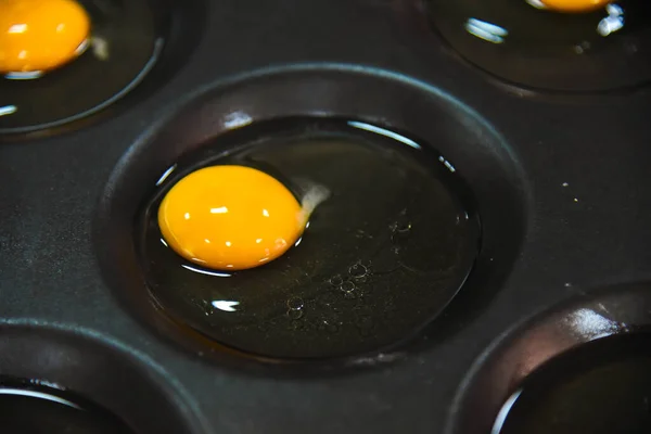 Broken eggs in special molds for cooking