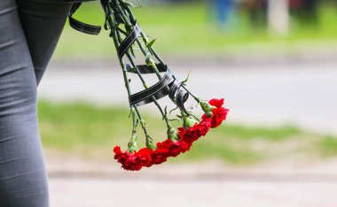 POLTAVA, UKRAINE  18 MAY, 2022: Red carnations (Dianthus) with black ribbon