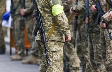 POLTAVA, UKRAINE 18 Mayıs 2022: Sarı bandajlı ve Kalaşnikof tüfekli Ukrayna Toprak Savunma Ordusu