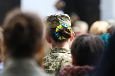 POLTAVA, UKRAINE  18 MAY, 2022: Ukrainian military with jewelry on her hair in yellow and blue colors
