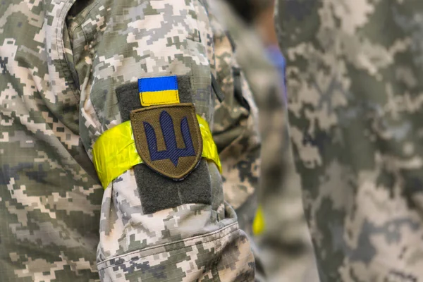 POLTAVA, UKRAINE  18 MAY, 2022: Chevron, yellow headband and Ukrainian flag in the uniform of the Ukrainian military