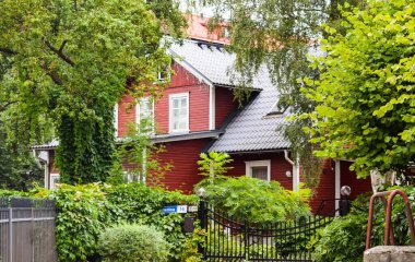 TALLINN, ESTONIA - 15 Ağustos 2018: Yazın yeşil ağaçların arasında çok katlı kırmızı ev