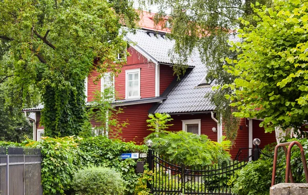 TALLINN, ESTONIA - 15 Ağustos 2018: Yazın yeşil ağaçların arasında çok katlı kırmızı ev