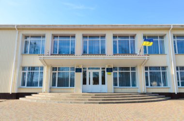 Sonbaharda gün içinde Ukrayna bayrağı taşıyan iki katlı bir bina.