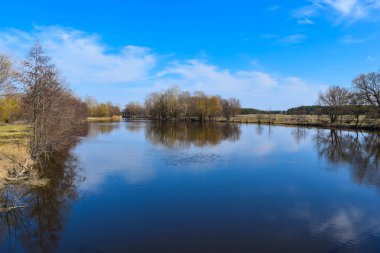 Sonbaharda öğleden sonra mavi gökyüzünün arka planındaki nehir.