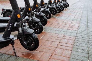 Sokakta elektrikli scooter park etmek. Scooter 'ın tekerlekleri arka arkaya. Mantıksal taşıma kavramı. Scooter 'ın siyah rengi