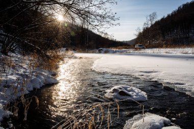 Su karın içinden akar. Nehir buzla kaplı. Ormana kış geldi. Tuz suya yansıyor. Soğuk zaman.