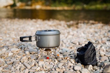 Yürüyüşte yemek pişirmek için alüminyum kap. Nehir kıyısında gaz ocağında yemek pişirmek. Yürüyüş için kompakt hafif ekipman. Yüksek kalite fotoğraf