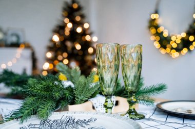 Yeni yıl ve noel fotoğrafı. Şampanya bardakları, bir buket çelenk ve parıltı. Tatil için hazırlık. Aileyle tatil, kış tatili.