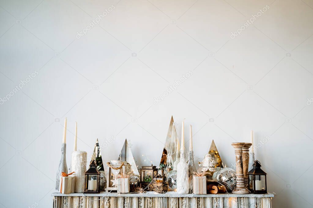 New Years decor on a minimalist white background. Candles, toys,gift box and lamps. Christmas and New Years mood. Preparations for the holiday, 