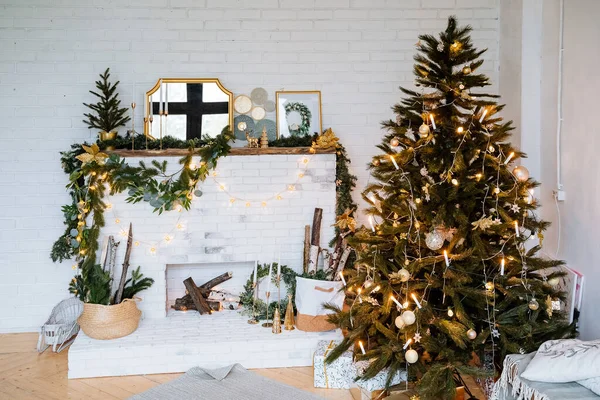 Yeni yıl ve Noel. İç mekan resmi. Şöminenin yanındaki Noel ağacı, ladin dalları, çelenk ve toplardan oluşan çelenk..