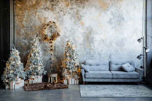 Odanın içinde yeni yıl. Dekorasyonlarda, süslerde ve çelenklerde yapay Noel ağaçları. Ladin dallarının çelengi. Noel ve Yeni Yıl havası.