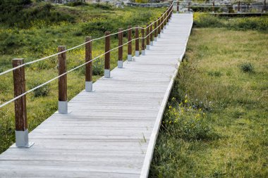 Tahta inişi. Beyaz odunların soyundan geliyor. Güzel bir sokak iç mekanı. Kıyıda taş çit var..