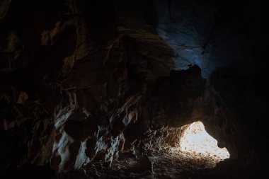 Tünelin sonundaki ışık. Mağaradan çık. Zindanda karanlık bir geçit. Speleotürizm.