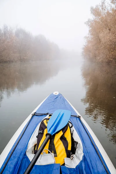 Na brzegu rzeki stoi kajak turystyczny niebieski do spływu po górskich rzekach. Żółty plecak leży w łodzi. Koncepcja spływu rzekami tajga. Jesienna wyprawa. — Zdjęcie stockowe