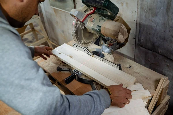 Procesamiento de madera Carpintero para cortar barras de madera, trabajar en el taller. Un plano de la sierra. Equipo en el taller de carpintería. — Foto de Stock