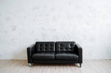 Minimalist tarzda mükemmel siyah deri kanepe. Modern mobilyalar, rahatlık ve konfor. Yüksek kalite fotoğraf