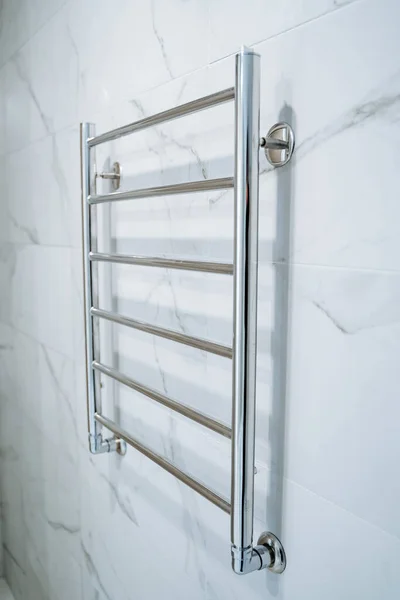 浴室的壁挂式毛巾烘干机 浴室的白色墙壁很醒目 金属加热毛巾护栏 现代房间 高质量的照片 — 图库照片