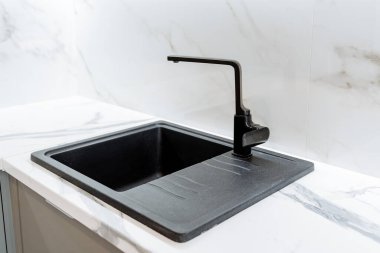 Siyah minimalist mutfak lavabosu. Mutfak modern bir dairede. Lavabo yapay, doğal taştan yapılmış. Minimalist iç çekim. Yüksek kalite fotoğraf