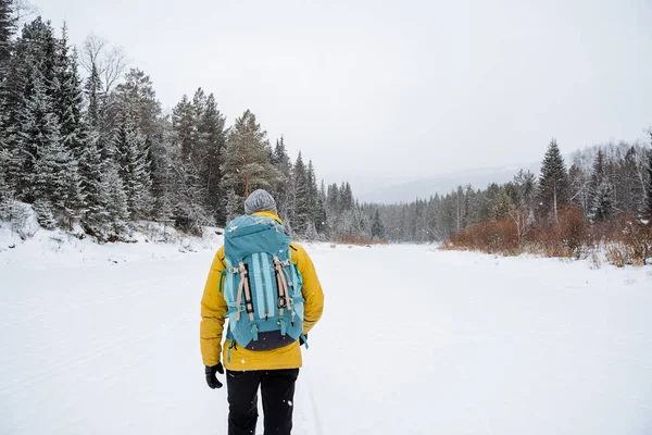 明るいバックパックを持つ楽しい旅行者は森を散策します 雪の森と岩 冬には山に登る 野生での生存 高品質の写真 — ストック写真