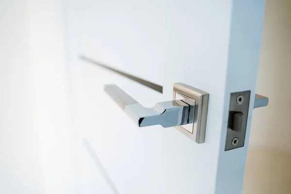 Metal kapı kolu. Odanın girişi beyaz bir kapıdan. Mobilyalar için metal teçhizat. Modern minimalist iç mekan. Yüksek kalite fotoğraf