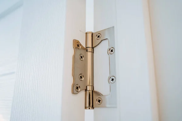 Mortise hinges on the white door. Home improvement. Hinges for interior doors. Wooden door in the house. Close-up