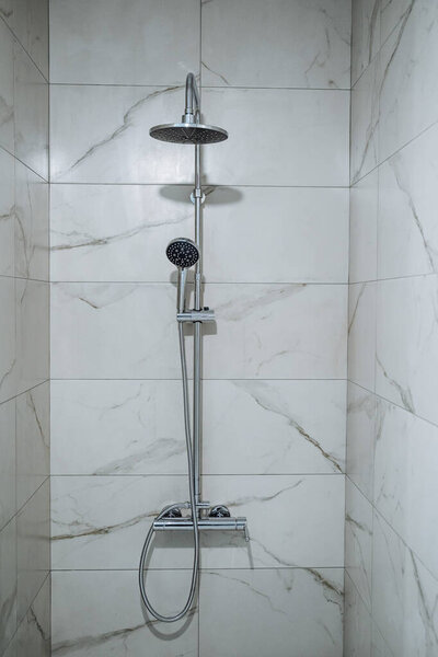 Shower in a marble booth. Shower system without a spill in a modern house. Contrast shower. Water treatments with comfort