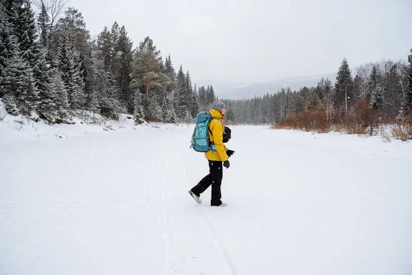 バックパックを背負った旅行者 ブッシュクラフト 雪の森と岩 冬には山に登る 野生での生存 高品質の写真 — ストック写真