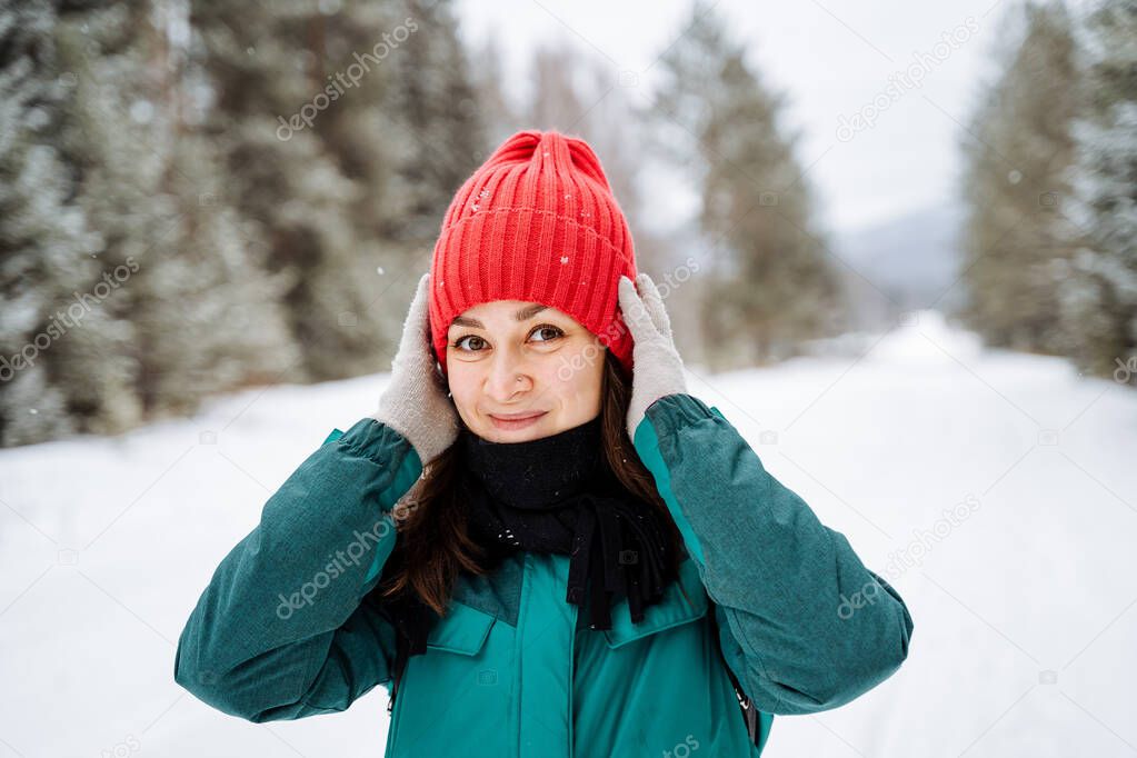 Happy and smiling girl walking in the winter forest. Snowfall. Bright winter equipment. Snow-covered forests. Walking in the winter season. High quality photo