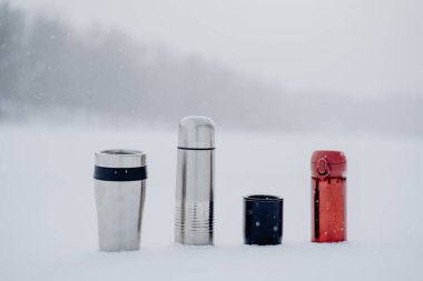 A set of thermoses of different sizes and shapes. Dishes for hot drinks. Tourist tableware made of metal. High quality photo