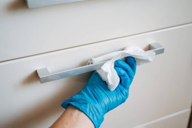 Temizlik şirketi evi temizliyor. Paçavralı bir el mutfaktaki çekmecelerin kapılarını siler. Odanın dezenfekte edilmesi, ıslak temizleme. Yüksek kalite fotoğraf