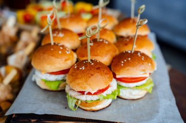 Hamburger bölümü yan görüntüde. Misafirler için masa ayarlayın. Tavuklu hamburger, beyaz çörek, marul, domates, susam. Fast food. Yüksek kalite fotoğraf