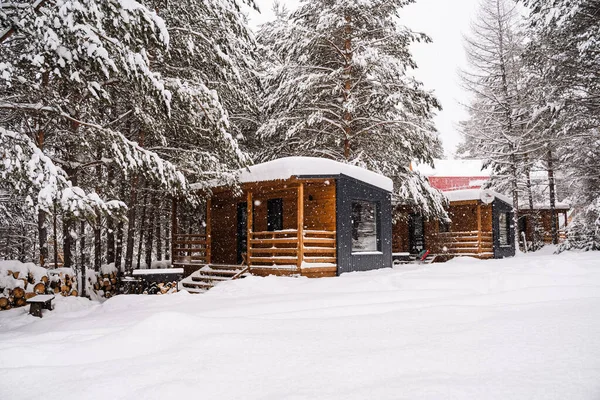 Modular house made of dark metal and light wood in winter forest. a house that takes into account everything you need for a comfortable life outside the city. High quality photo