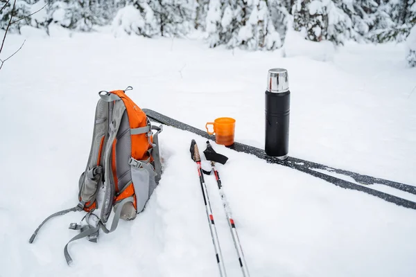雪の中のスキー場にティースタンドがある魔法瓶 雪の中には鮮やかなオレンジ色のハイキングバックパックが横たわっている 冬のスキー 高品質の写真 — ストック写真