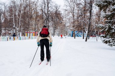 Sırt çantalı bir kayakçı şehir parkından geçiyor. Yılın herhangi bir zamanında spor. Sağlığınıza dikkat edin. Yüksek kalite fotoğraf