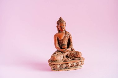 Minimalist pembe arka planda Buda heykelciği. Ohm. Budizm. Üç dünya dininden biri. Sakinleştirici Meditasyonlar ve Nirvana. Yüksek kalite fotoğraf