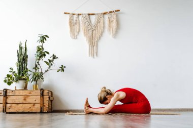 Spor ev karantinasında. Esneme hareketleri yapan bir kadın Asya yogası yapar. Paschimottanasana İleri Eğil. Yüksek kalite fotoğraf