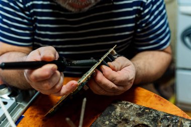 Elli lehim elektronik çipi. Güzel el yapımı. Elimde lehimleme demiri var. Yüksek kalite fotoğraf