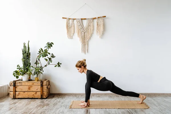 Yoga evde genç ve güzel bir kız tarafından yapılır. Sağlığınla, iç huzurunla, iç huzurunla, vücut eğitiminle ilgilenmek. Yüksek kalite fotoğraf