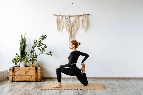Paspasın üzerinde yoga egzersizi. Genç ve güzel bir kız evinde spor yapıyor. Vücudun sabah ısınması, sağlığınla ilgilenmek. Yüksek kalite fotoğraf