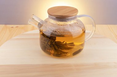 Tahta bir masada sıcak bitkisel çaydanlık..