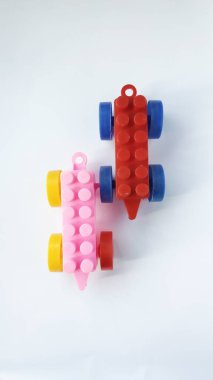Beyaz arka planda lego kübü dolu oyuncak bir araba. Eğitici oyuncaklar