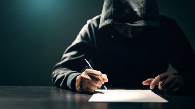 Erkek hırsızlar iddiaları kabul etmek için itirafı kağıda imzalarlar. Adam siyah bir palto giymişti ve saldırıdan sonra polis tarafından tutuklandı..