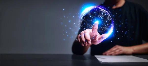 Man\'s hand pointing finger at virtual world and blue lighting, The concept of the business world without borders, the communication connection of the future. Virtual Metaverse Technology.